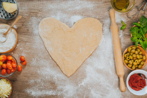 istock Heart shape homemade pizza dough on the table 1366967655