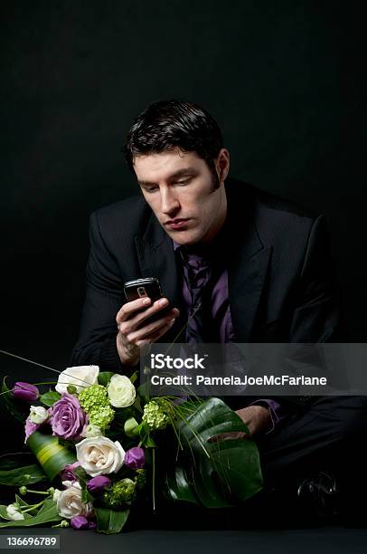 Giovane Uomo Aspettando Con I Fiori Controlli Telefono Cellulare - Fotografie stock e altre immagini di Abbigliamento elegante