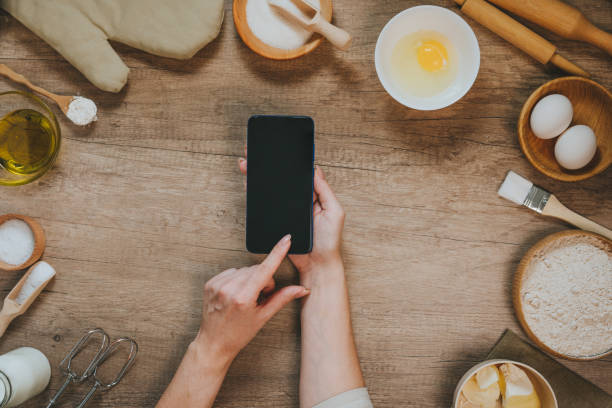 istock Female hands using smartphone with epmty screen near ingridients 1366967931