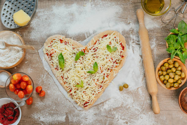 istock Heart shape homemade pizza on the table 1366968095