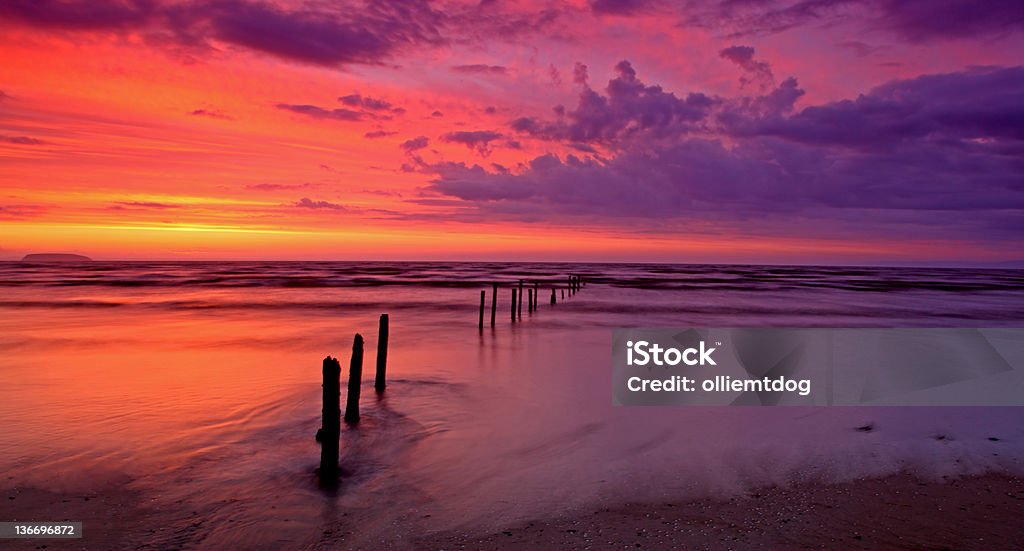 Sunset waters Fiery sunset at berrow sands burnham england Beach Stock Photo