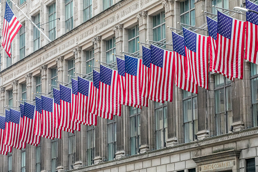 American flags hanging on facade of Skyscraper in New York City