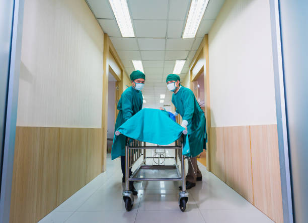 istock doctors push patient bed into operating room 1366969172