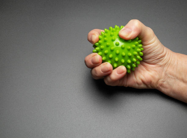 la main d’une femme âgée serre une boule de soulagement. exercices pour les mains et les doigts. réhabilitation - massage ball photos et images de collection