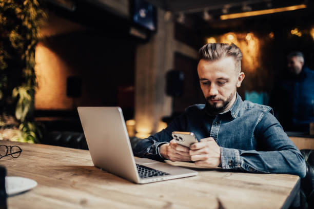 istock male freelancer communicates in a smartphone in a coworking cafe, testing mobile applications, online work. 1366969753