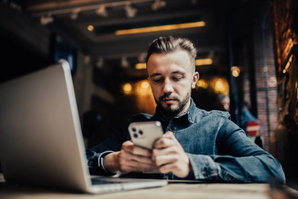 istock male freelancer communicates in a smartphone in a coworking cafe, testing mobile applications, online work. 1366969839