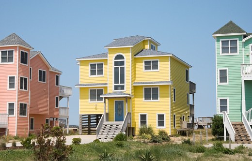 Row houses in colorful pastels, rental condos in a seaside resort town with the ocean lying just behind, Outer Banks, North Carolina, NC, USA.