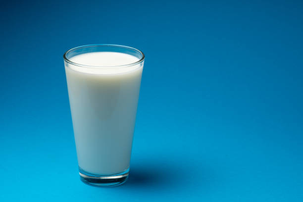 istock Glass of fresh milk isolated on blue background. 1366972464
