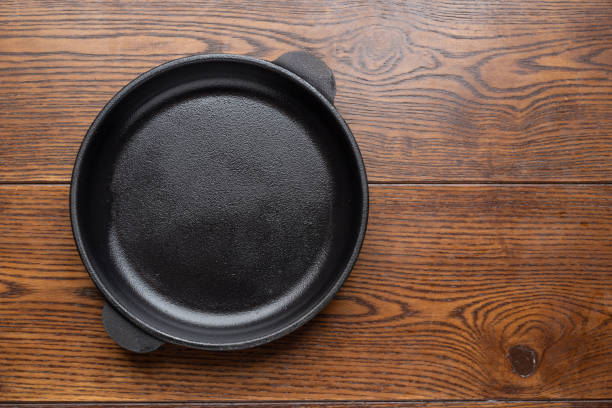 istock Empty frying pan on wooden background. Top view. 1366972593