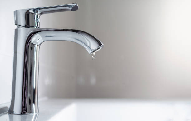 bateria z kroplą wody przed białym zlewem. - leaking faucet water scarcity zdjęcia i obrazy z banku zdjęć