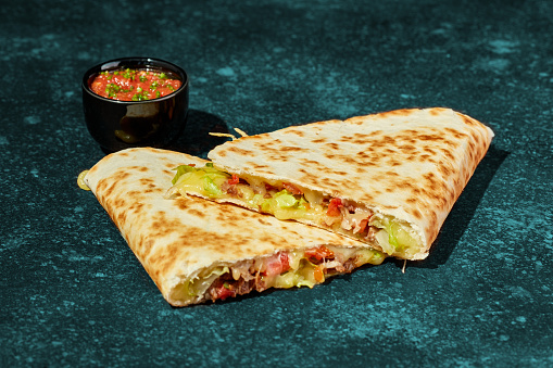 Quesadilla with chicken, cheese, vegetables and herbs and sauce.