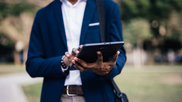 istock Close up of unrecognizable black business man using a tablet in a park downtown 1366972758