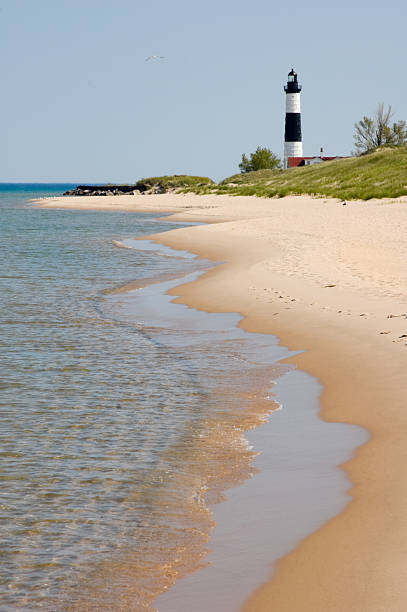 istock Beach with Waves and Lighthouse, Michigan Great Lakes Scenery 136697312