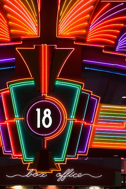 Theater box office neon sign photographed at night, vivid colors and shapes against a black background, close up.