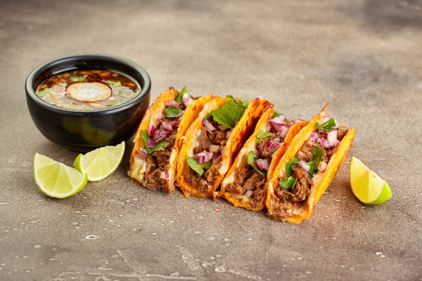 Traditional mexican birria consome soup and four taco with stewed beef Traditional mexican birria consome soup and four taco with stewed beef. taco stock pictures, royalty-free photos & images