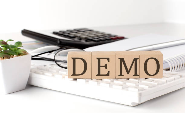 DEMO written on a wooden cube on keyboard with office tools stock photo