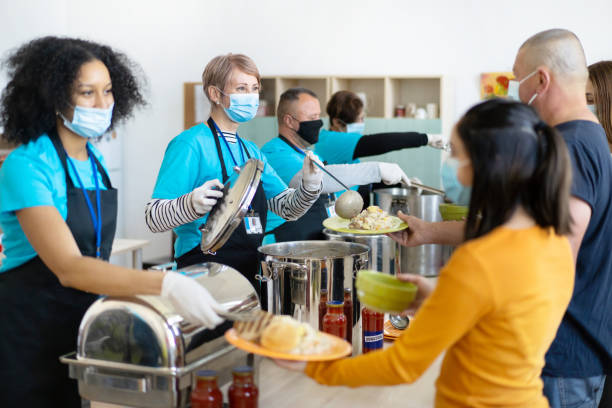 istock Serving meals to homeless people in a soup kitchen. 1366974932