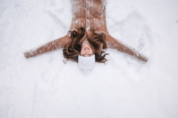 Happy holidays, beauty and winter fashion, beautiful woman wearing white fluffy fur coat, snowing snow on blue background as Christmas, New Year and holiday lifestyle portrait style