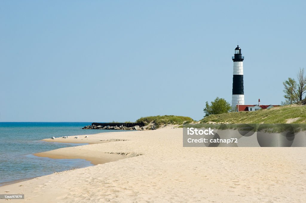 Lighthouse and Beach Sand Along Shoreline, Michigan Great Lakes Scenery Lighthouse along a sandy beach shoreline, a state park in Michigan Great Lakes, MI, USA. Michigan Stock Photo