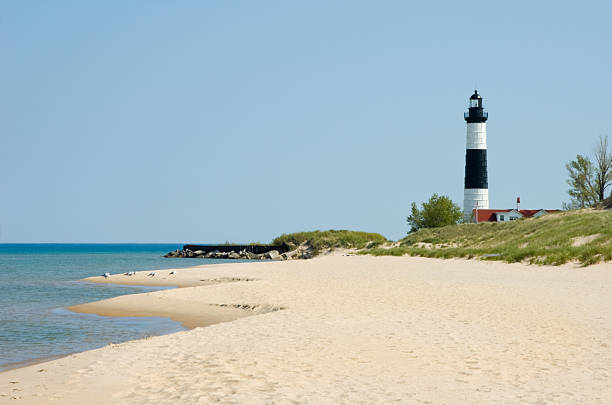 Lighthouse and Beach Sand Along Shoreline, Michigan Great Lakes Scenery stock photo