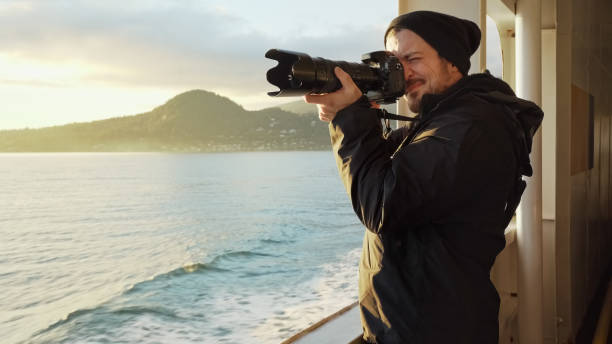 istock Young man taking photos from a cruise liner 1366979721