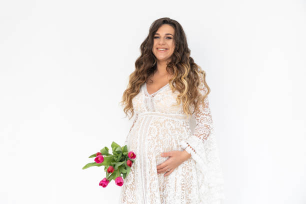 mujer embarazada con el ramo de flores en el vestido blanco. - human pregnancy flash fotografías e imágenes de stock