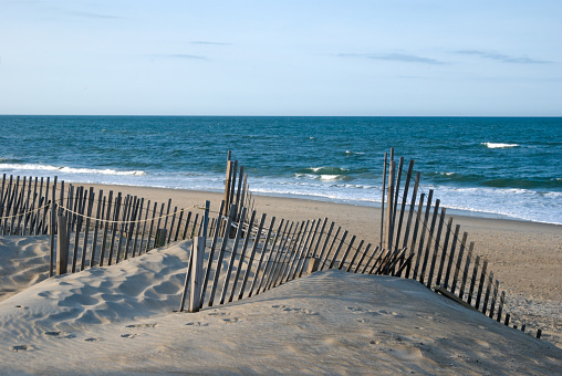 Sand dunes and surf in low evening light near dusk, looking out to sea, Outer Banks, NC, USA.