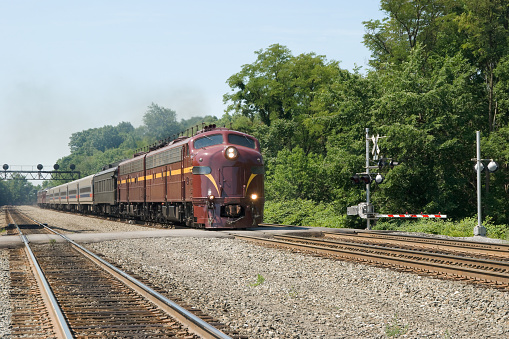 Train at grade crossing, diesel locomotives pulling a toursit excursion on the old PRR mainline at Altoona, Pennsylvania, PA, USA.
