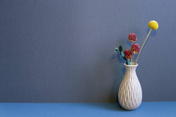 wazon z suchymi kwiatami na stole. granatowe tło ściany. wystrój wnętrz domu - globe amaranth zdjęcia i obrazy z banku zdjęć