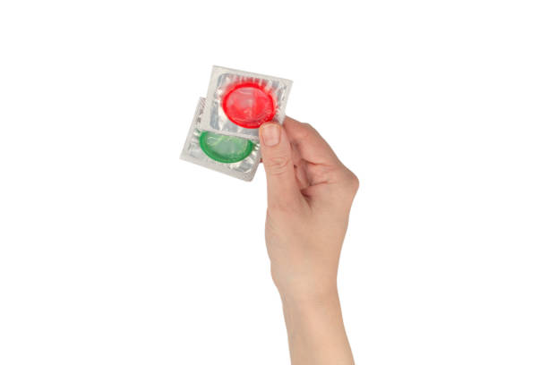 istock Condom in woman hand isolated on white background. 1366988720