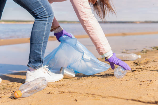 istock A female volunteer cleans plastic garbage in nature. 1366989091