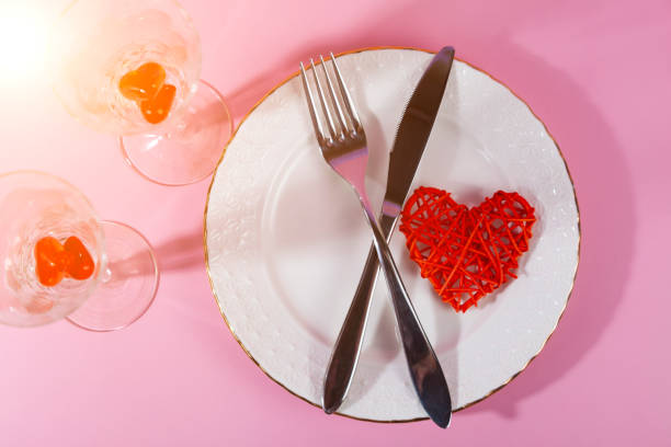 istock Valentine's day romantic dinner with red hearts on pink background. 1366990264