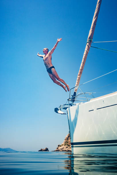 istock Man jumping in sea from sailboat 1366991584