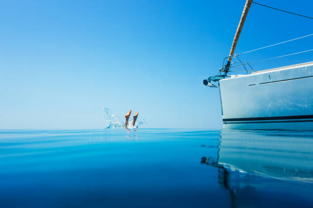 istock Man jumping in sea from sailboat 1366991628