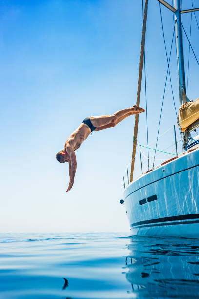 istock Man jumping in sea from sailboat 1366991643