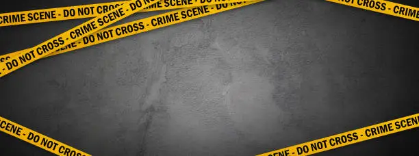 Photo of Yellow police line - do not cross on concrete wall background with copy space. Crime scene dark banner for true crime stories or investigations podcast.