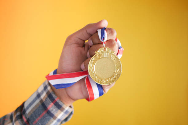 istock First Place Throphy against yellow background 1366993237