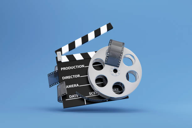 istock Cinema Clap and Film Roll on blue studio background 1366993731