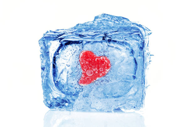 istock Red heart frozen inside blue ice cube on white background. Valentines day card 1366995178