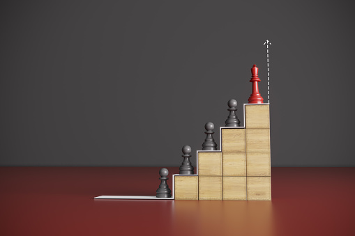 Red colored king of chess, standing on the top of the pawns and wooden blocks, symbolizing a chart of hierarchy, leadership concept. (3d render)