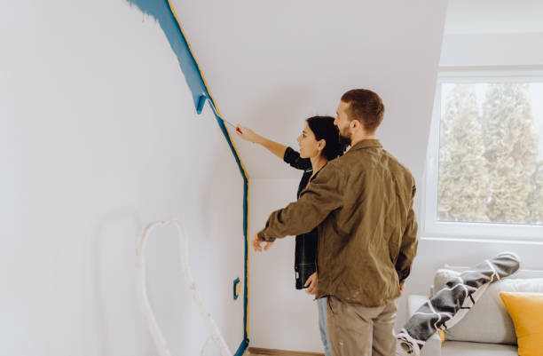 istock Young couple paint together a wall in their apartment 1366996331