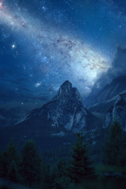 Nature landscape with a mountain peak under a starry night sky.