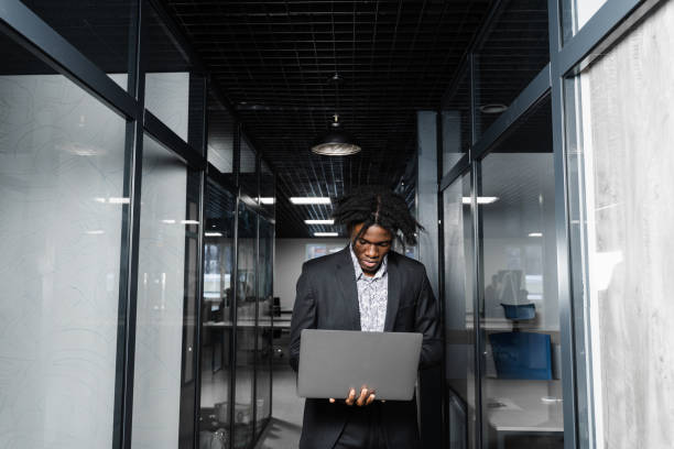 istock Focused young black businessman working online on laptop in office. Remote work. 1366998983