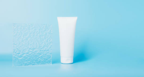 istock Cosmetic product in a tube, white container blue background. Shampoo, hand cream, toothpaste white packaging 1366999432