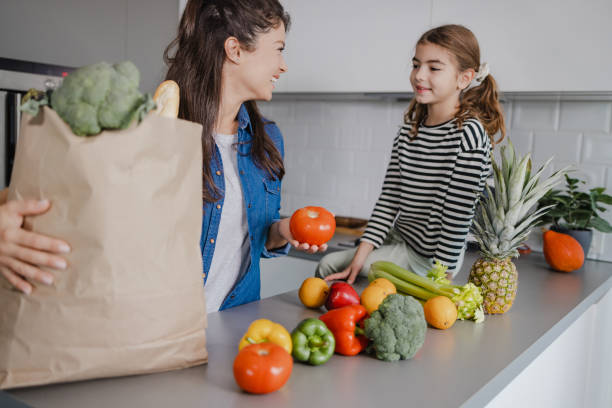 istock Mother and daughter returning from groceries shopping 1366999532