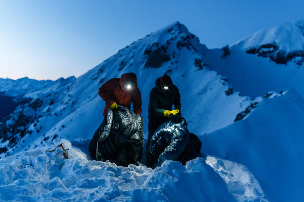 登山家は雪の中で冬のキャンプに備える - extreme terrain powder snow winter snow ストックフォトと画像