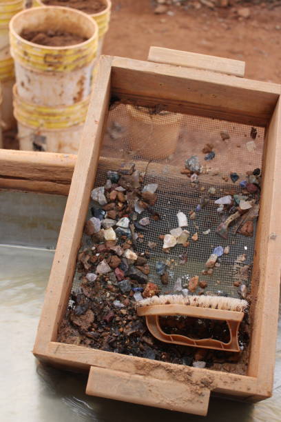Stones in Sluice Box Semi-precious gem stones in sieve-like box after sluicing, a process of washing away dirt in a stream or trough to reveal stones sluice photos stock pictures, royalty-free photos & images