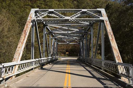 Old metal girder bridge in the mountains carrying two lane highway, front view, Kentucky, KY, USA.