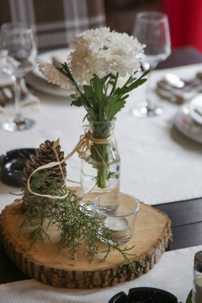 istock Simple and elegant table setup with dinner set and bouquet o f white flowes. Emty restaurant tables before the event. 1367004064