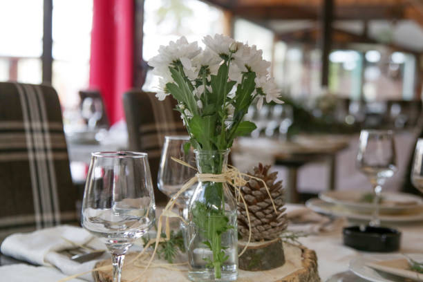 istock Simple and elegant table setup with dinner set and bouquet o f white flowes. Emty restaurant tables before the event. 1367004079